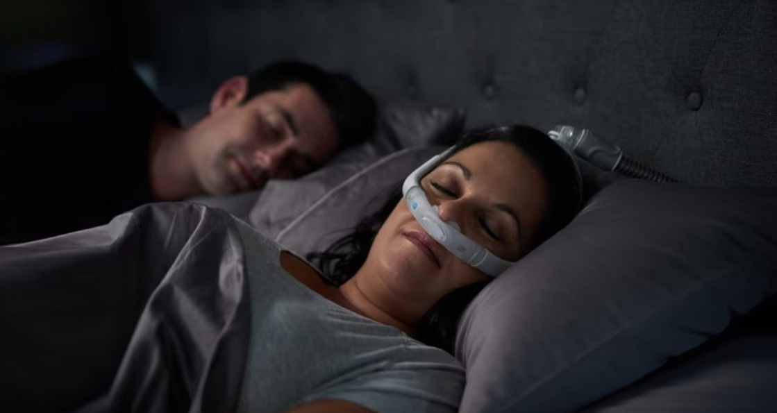 Woman sleeping comfortably wearing a nasal CPAP mask